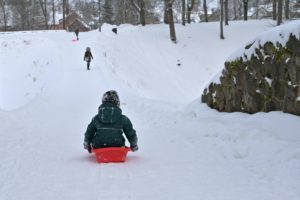 A child sledding down a snowy hill