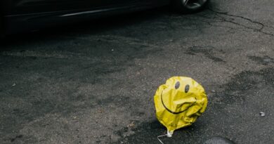 Photo of a deflated balloon with a smiley face on it