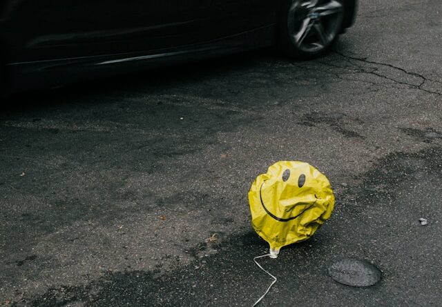 Photo of a deflated balloon with a smiley face on it