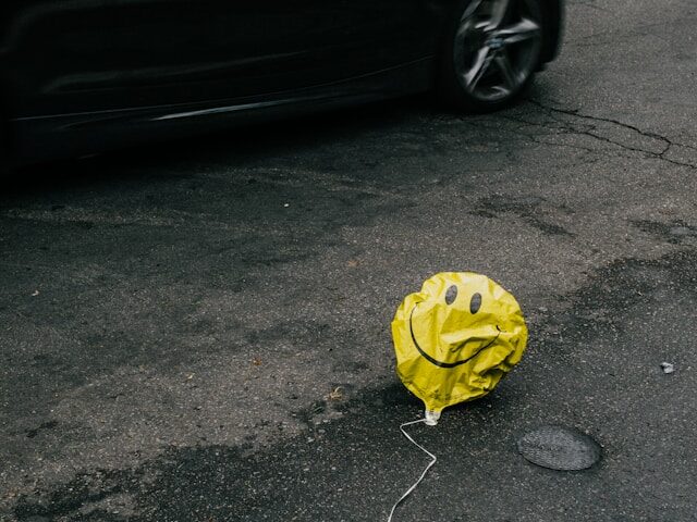 Photo of a deflated balloon with a smiley face on it