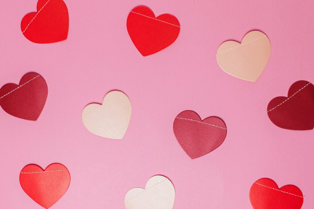 Image of paper hearts on a pink background