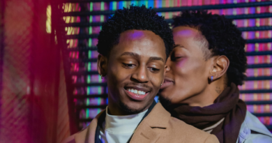 Positive Black Same-Sex Couple Embracing Gently Against Colorful Wall