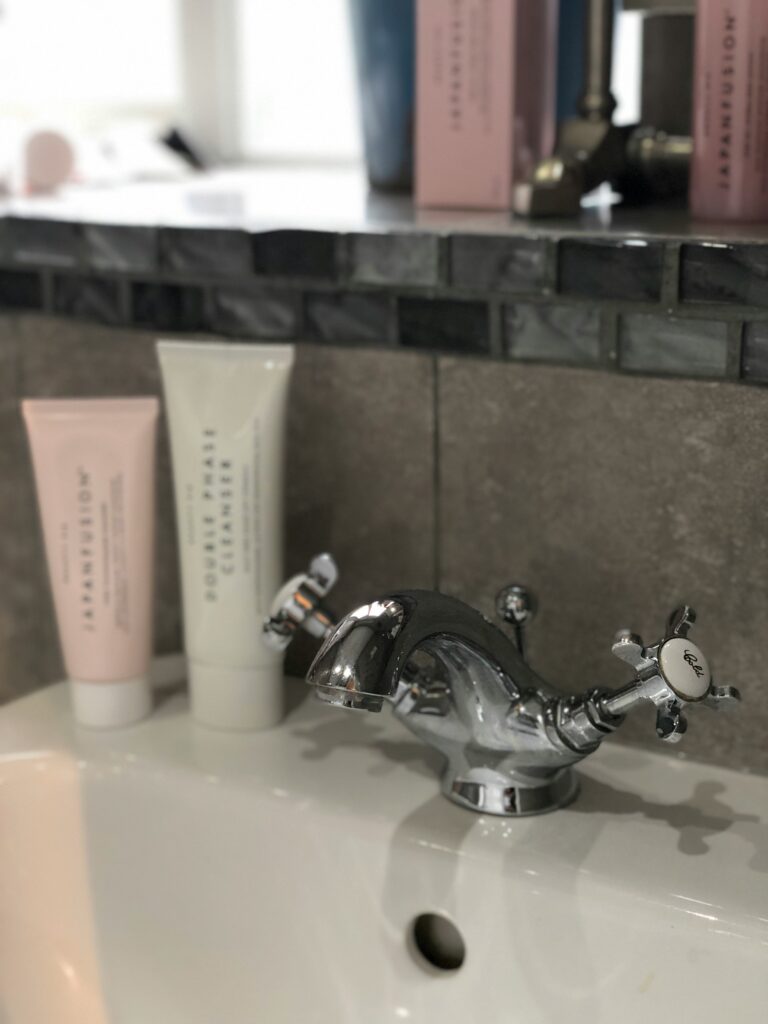 Skincare products on a sink.