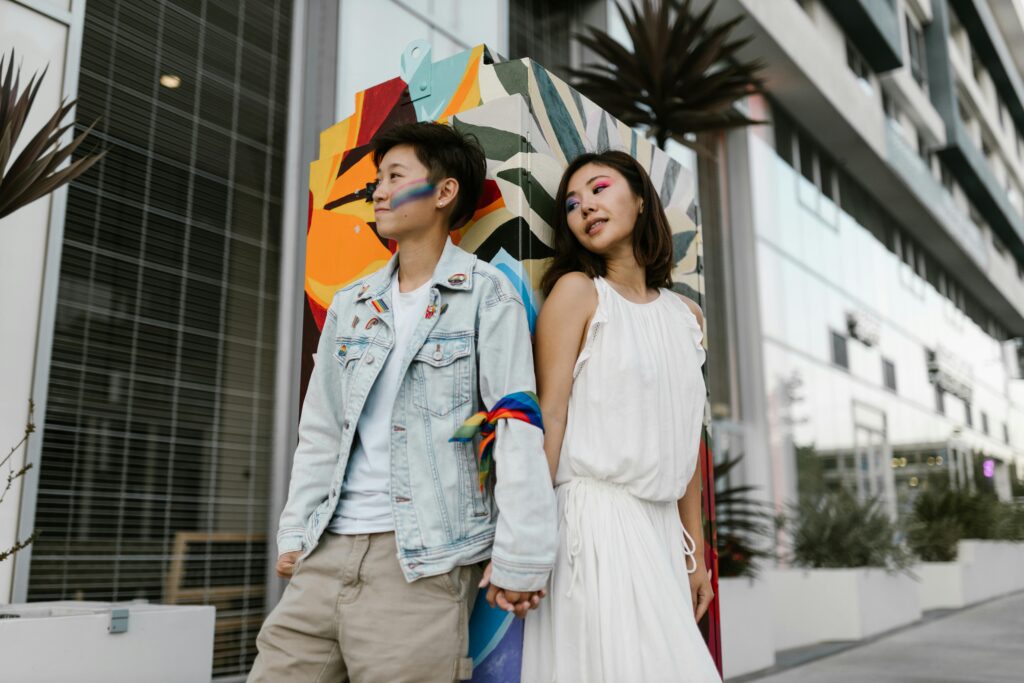 Lesbian Couple Wearing Pride Merchandise Holding Hands